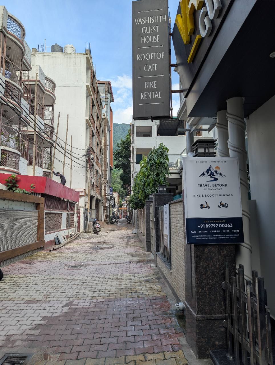 Street approach with the Travel Beyond Himalayas rental sign beside Vashishth Guest House